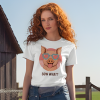 Load image into Gallery viewer, Woman wearing a white t-shirt with a graphic of a pig wearing sunglasses and text, standing outdoors.